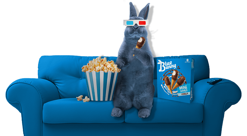 Blu the bunny wears 3D glasses while sitting on a blue couch, holding a Mini Swirls Vanilla ice cream cone, next to a tub of popcorn and a box of Blue Bunny Mini Swirls Vanilla ice cream cones.