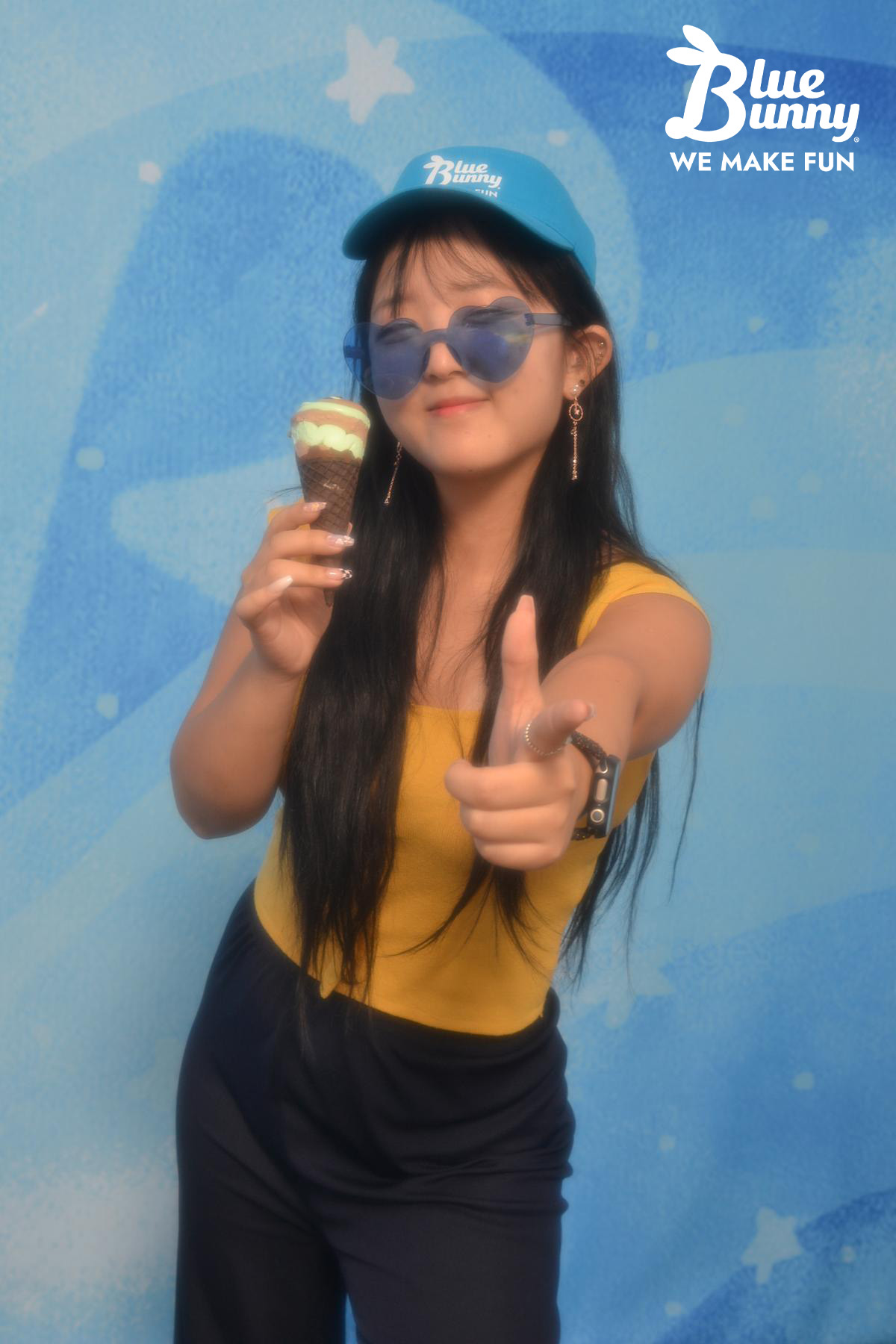 Girl pointing at the camera holding a twist cone