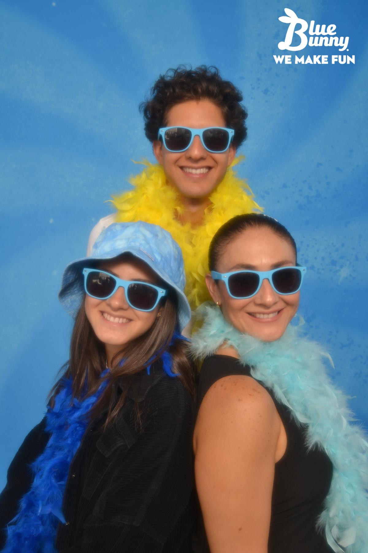 Three people with sunglasses and boas