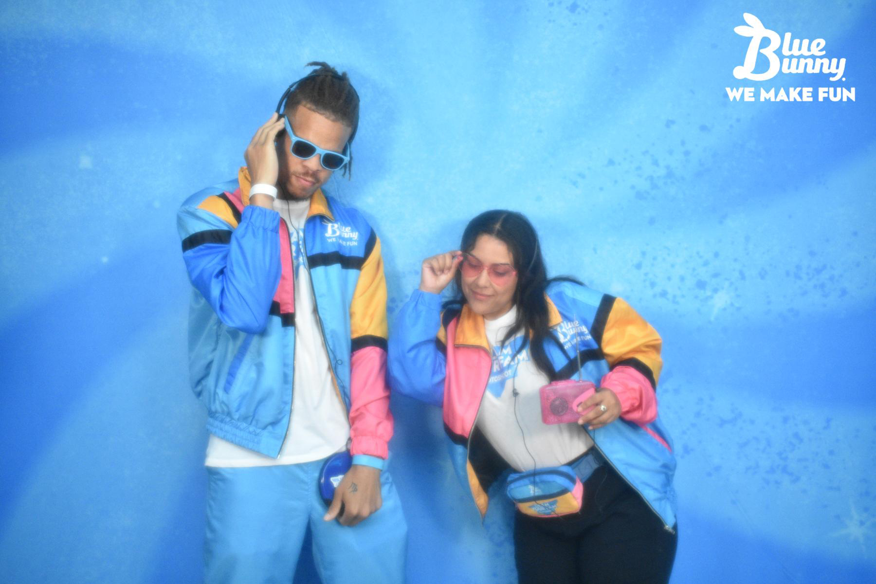 Man and woman in a sweatsuit wearing sunglasses pretending to be DJs