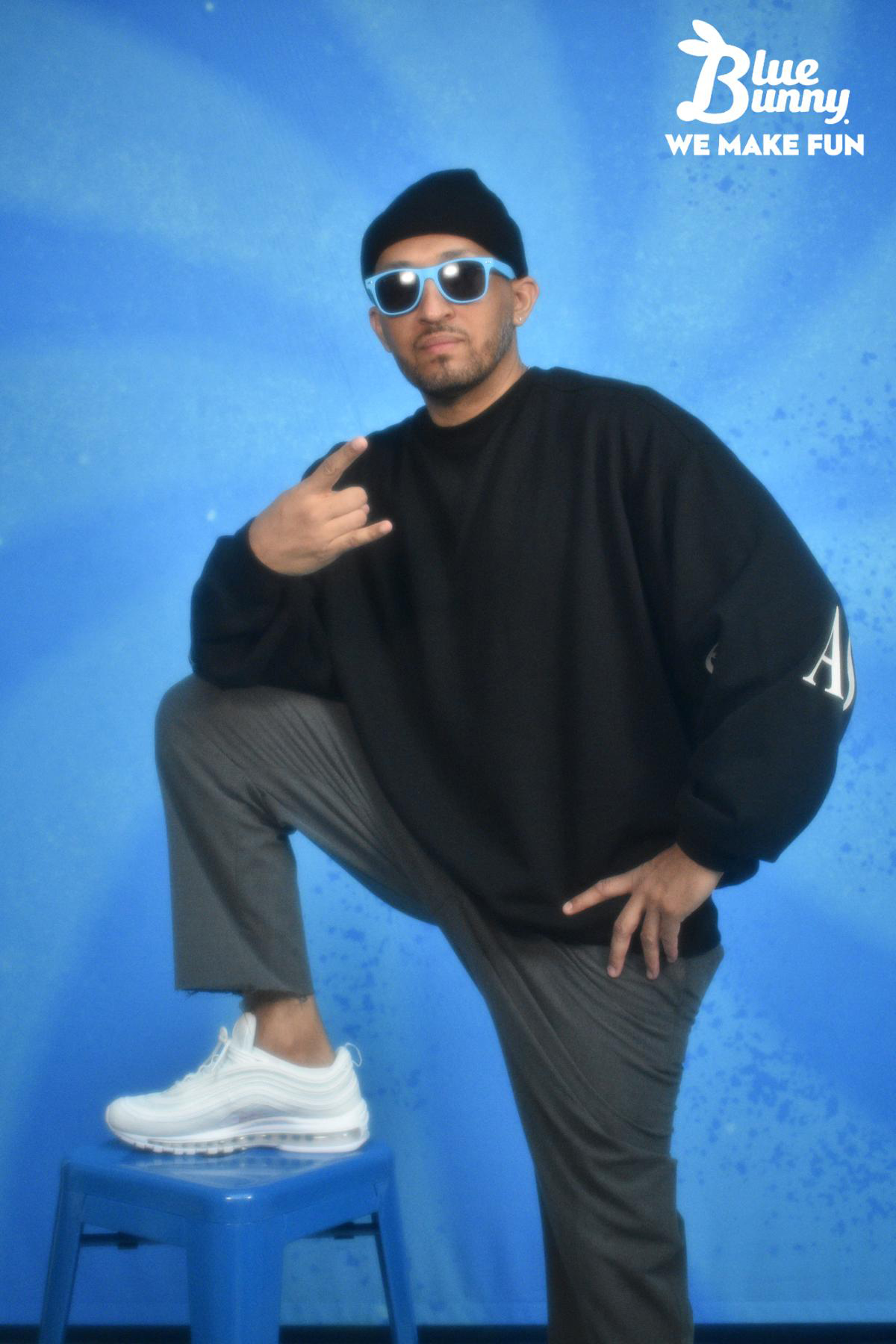 Man with his foot up on a stool wearing blue sunglasses